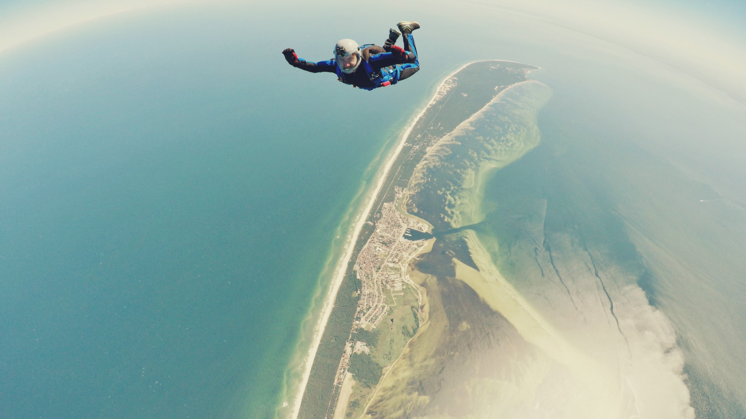 skydiver in freefall above a portion of the coast