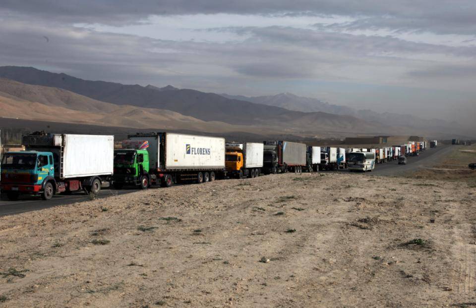 a long line of semi trucks stretching into the distance on a highway